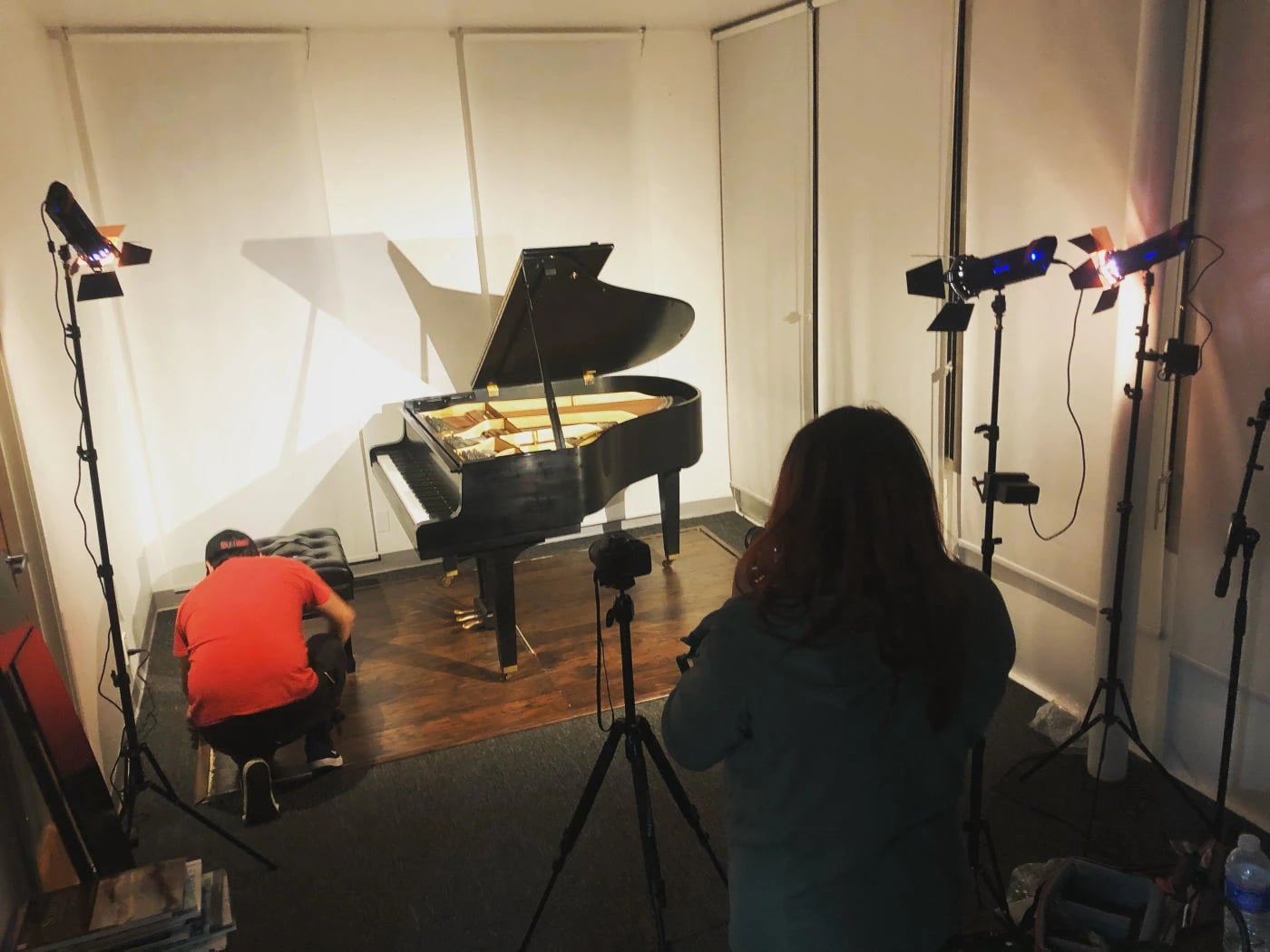 Recital hall with a Yamaha grand, lights, and a camera crew